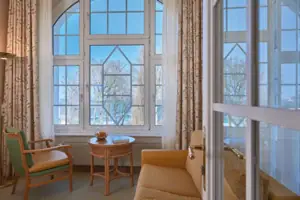 Suite Living room with couch and table, window in the background.