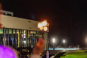 A person stands in front of a building at night.