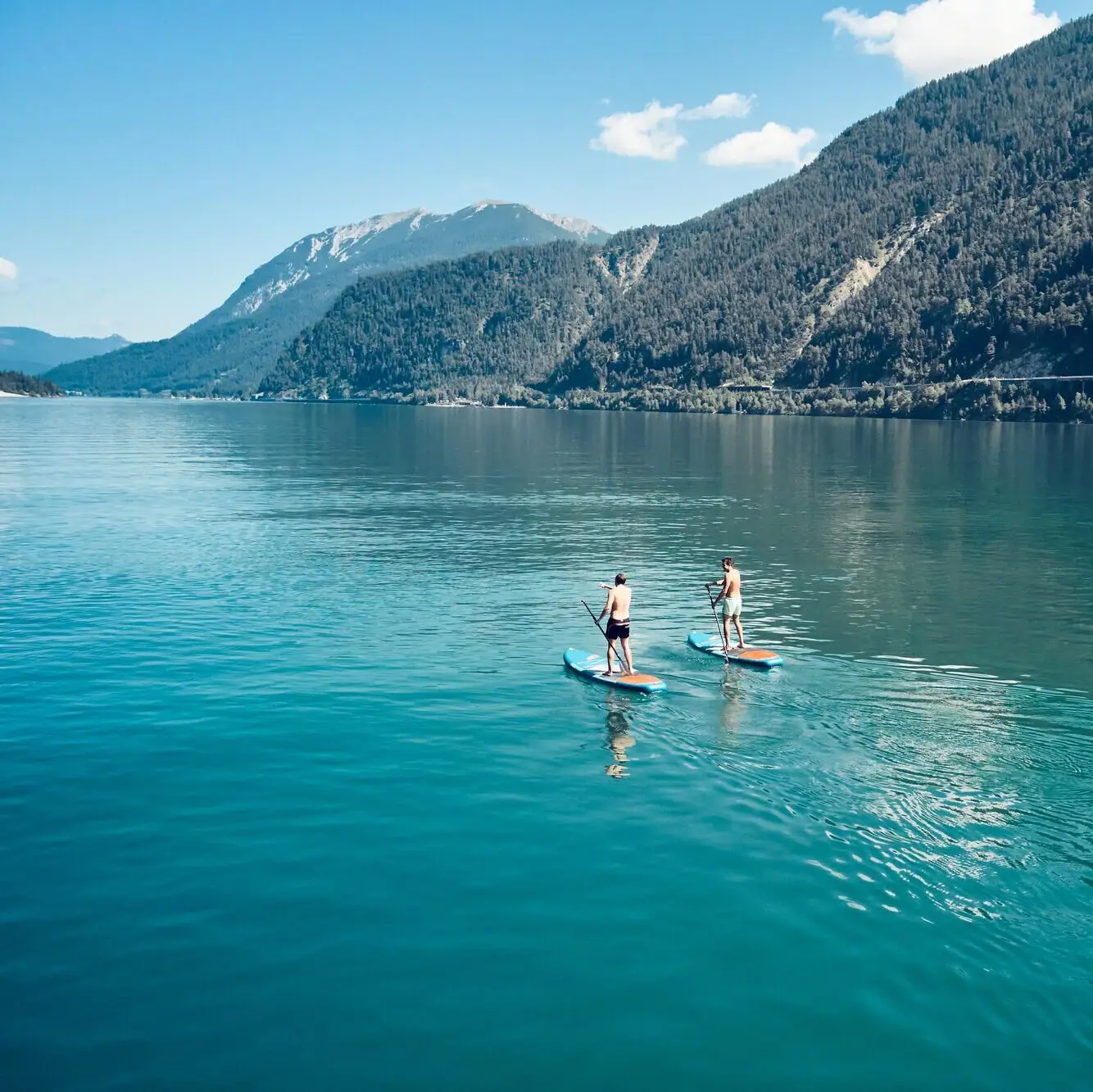 Stand-up paddling Two people on paddleboards on a lake