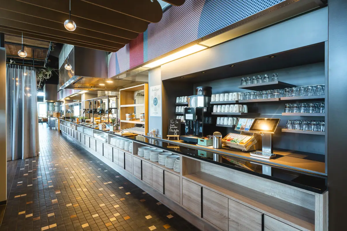 The buffet restaurant with counters and shelves full of crockery.
