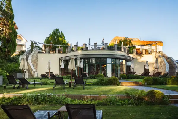 North Perd & Villas Lawn with chairs and parasols in front of a building