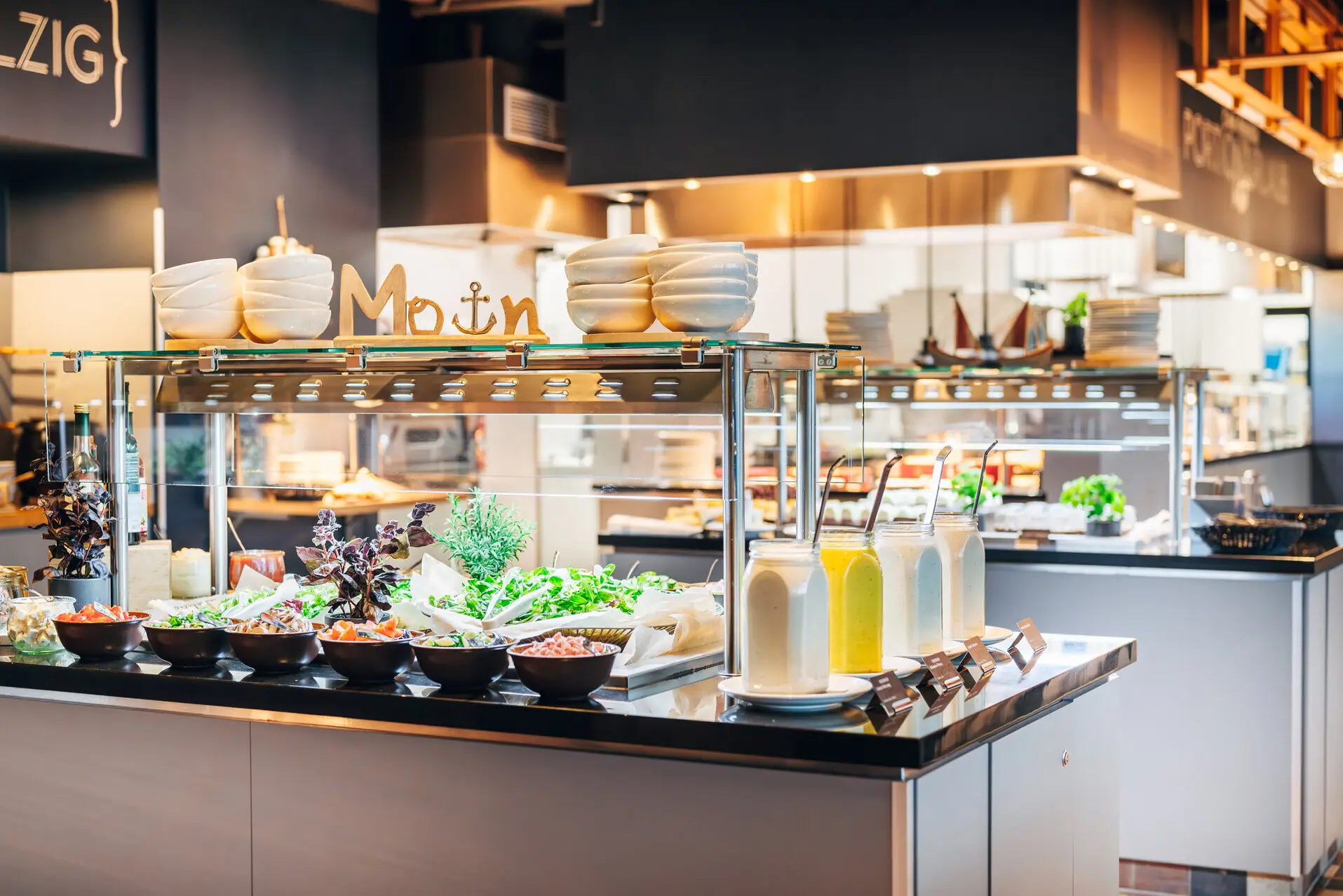 Counter with salads and jars filled with various dressings.