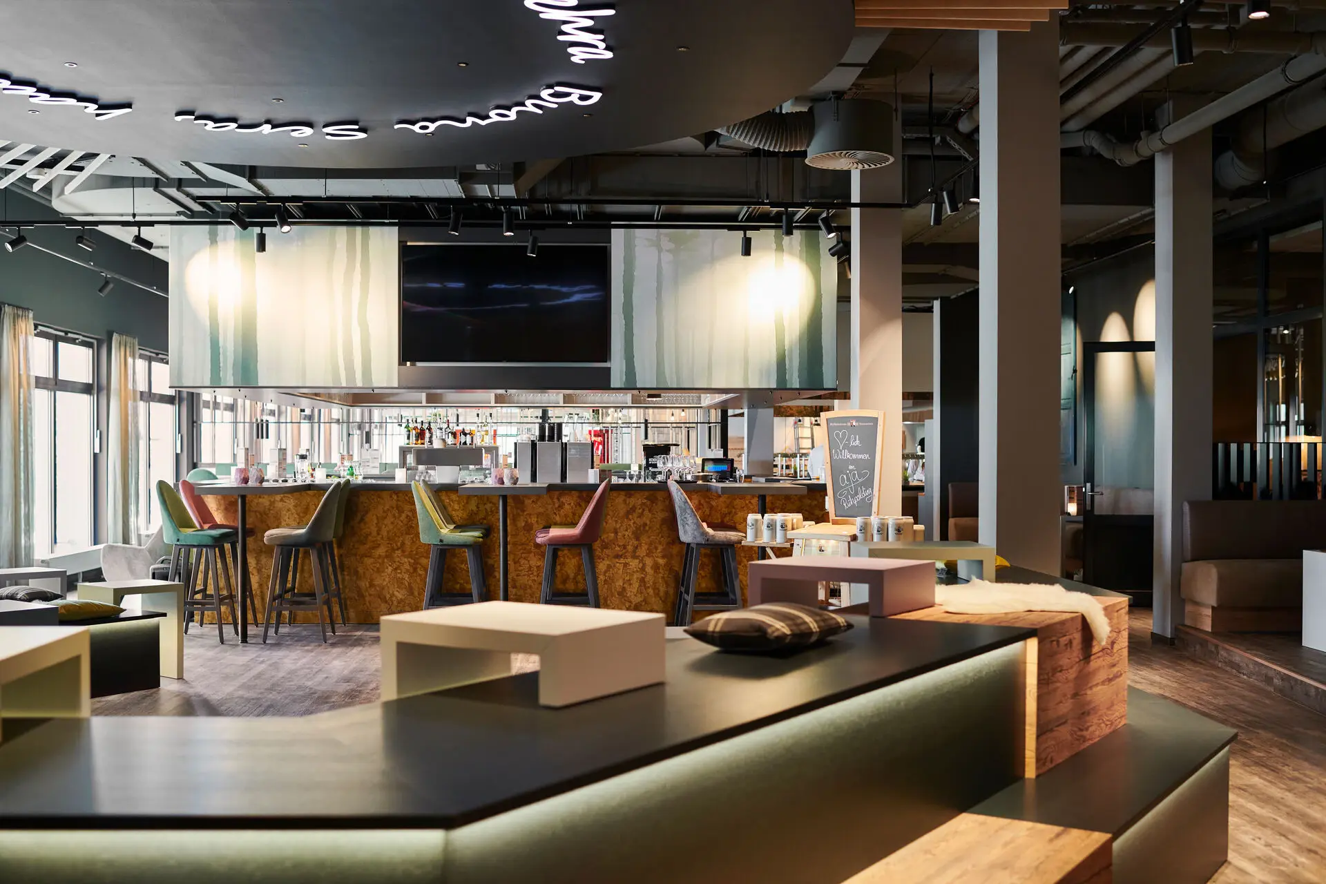 Bar at the aja Ruhpolding A bar with television and bar stools.