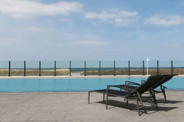 A swimming pool with chairs and a flag at the side.