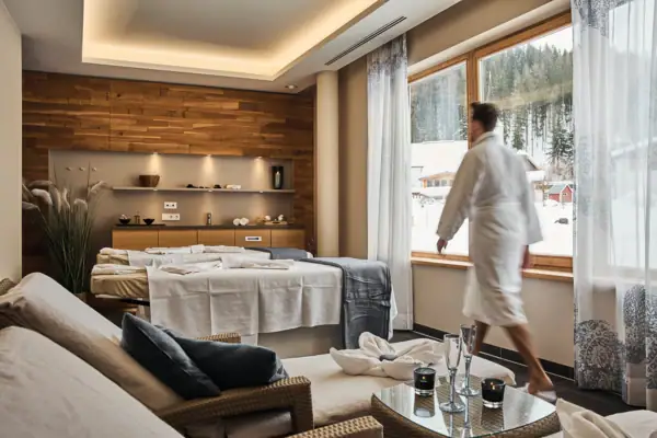 A man walks through the SPA suite with a bed and a table.