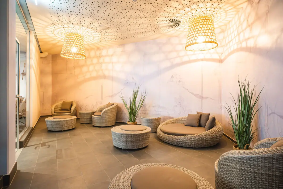 A room with wicker furniture and houseplants.