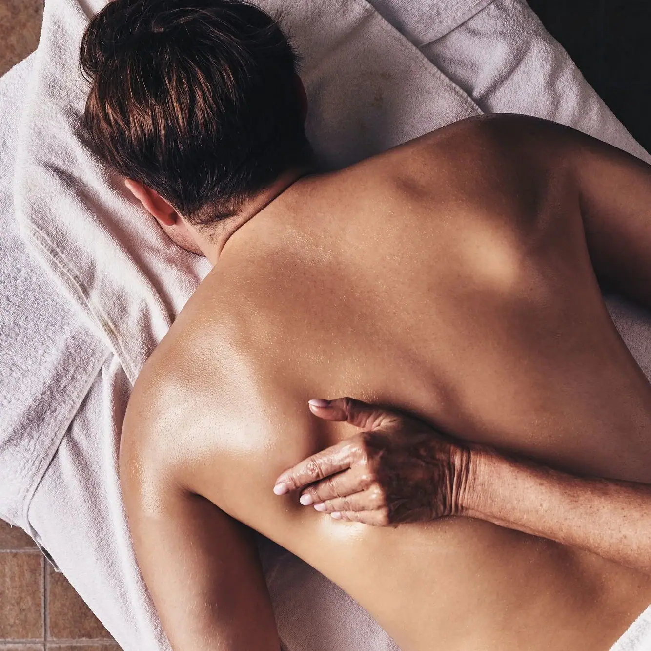 Massage  A person lies on their back on a towel.