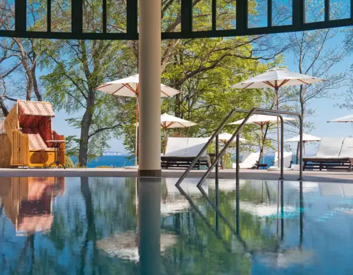 A pool with a deckchair and parasols.