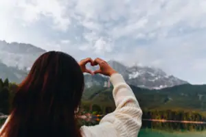 A woman forms a heart with her hands.