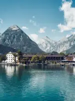 Building next to a body of water with mountains in the background.