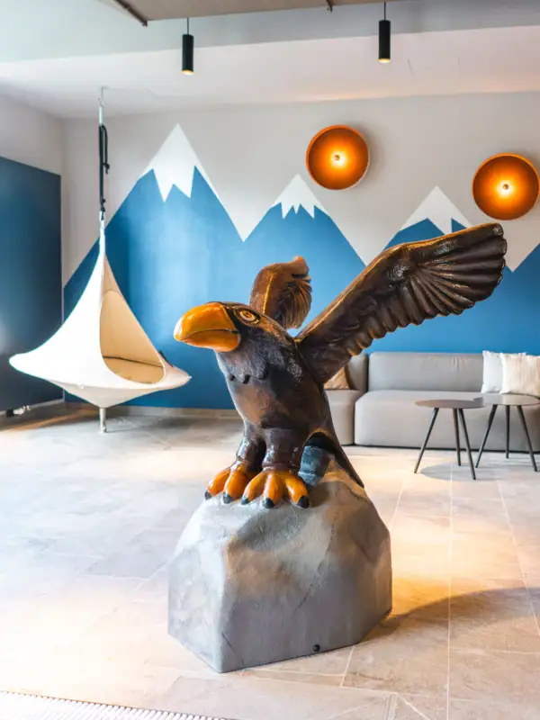 Children's pool Statue of a bird on a rock in a room with a couch and hammock