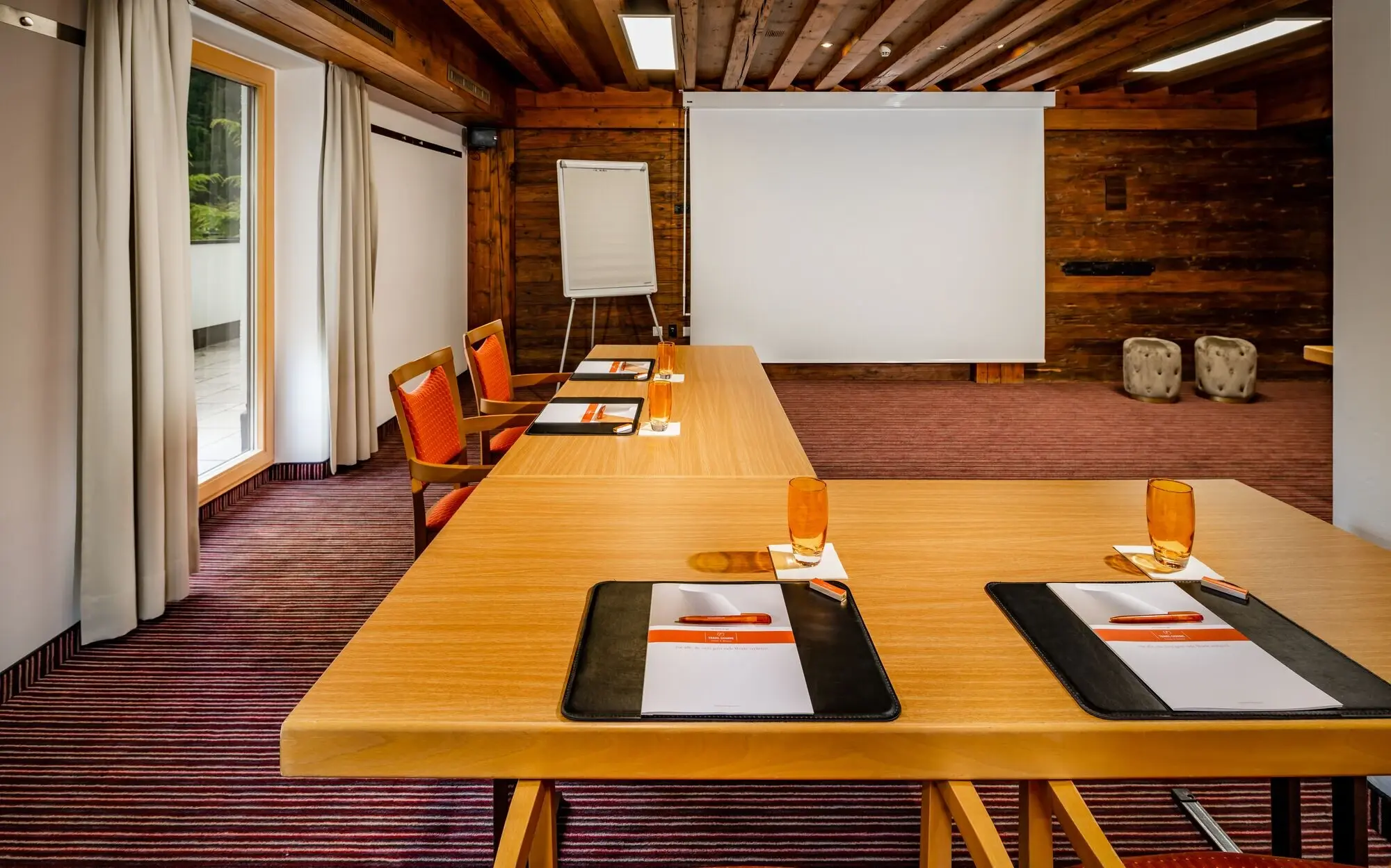 A room with a large white screen and several tables.