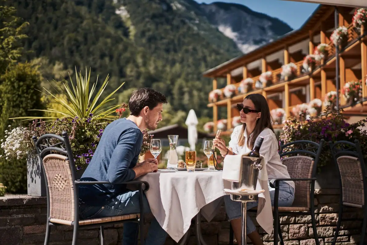 Outdoor terrace A man and a woman are sitting at a table with drinks.