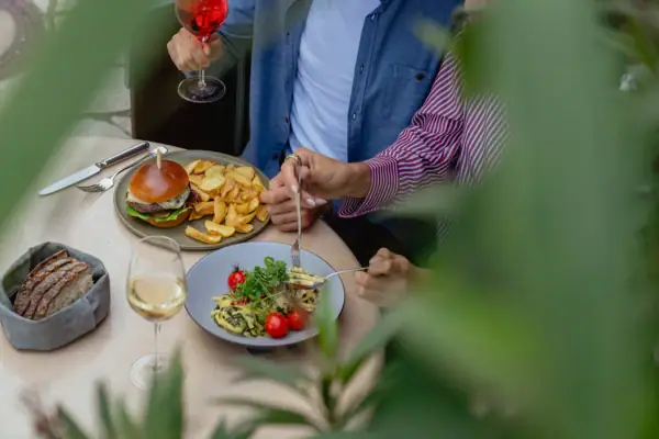 A man and woman eating a meal at a table with various tableware and plates.