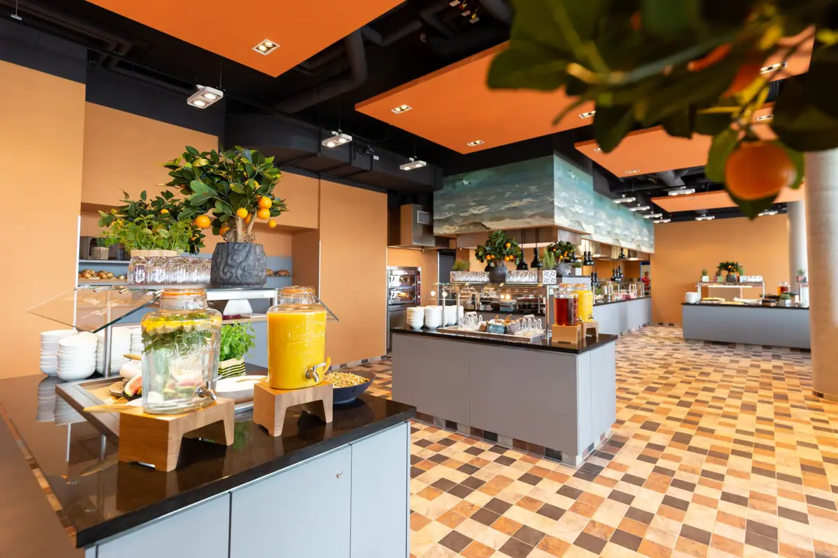 A room with orange and yellow drinks and food on a worktop.