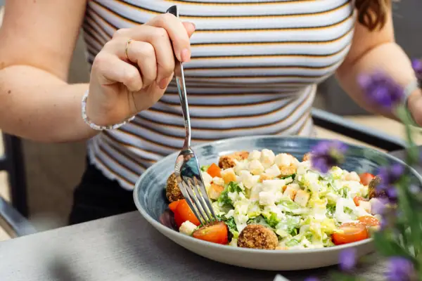 A woman eats a salad.