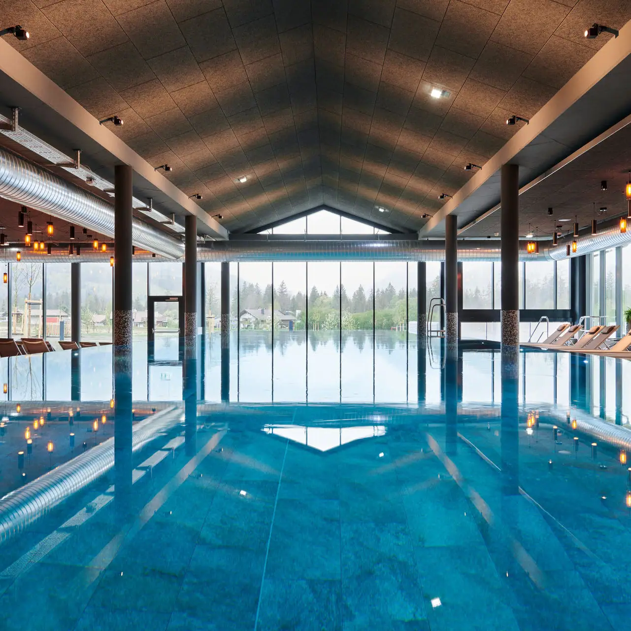 Indoor pool at aja Ruhpolding Large indoor pool with high ceilings and large windows.