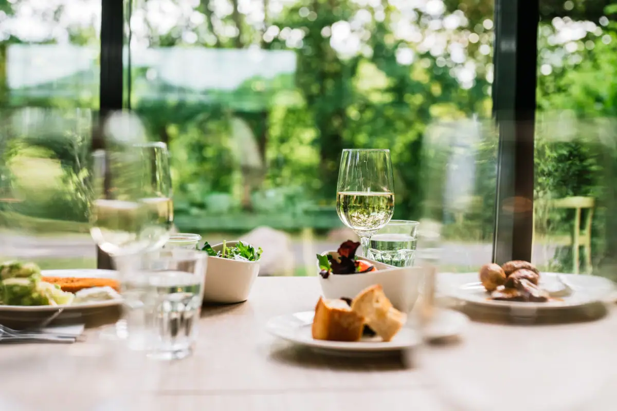 A table with various dishes and wine glasses.