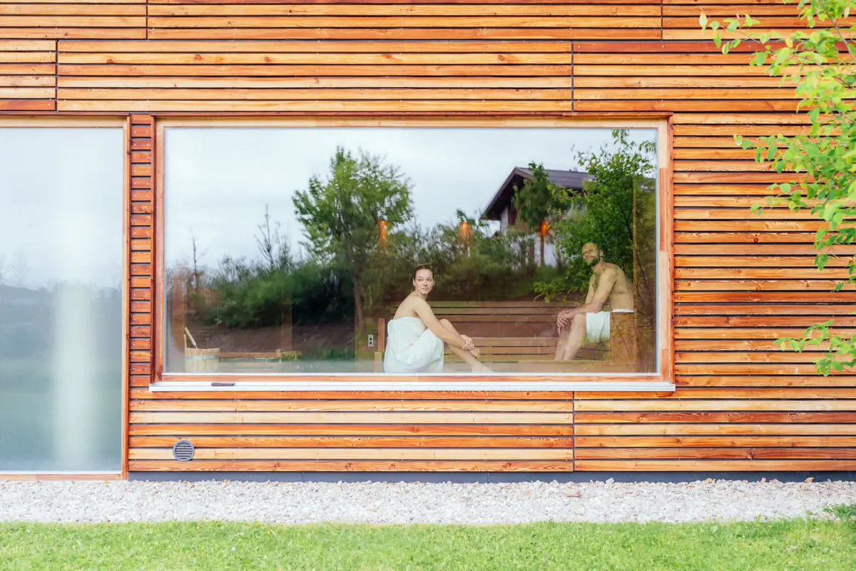 A man and a woman are sitting on a bench in a wooden house.