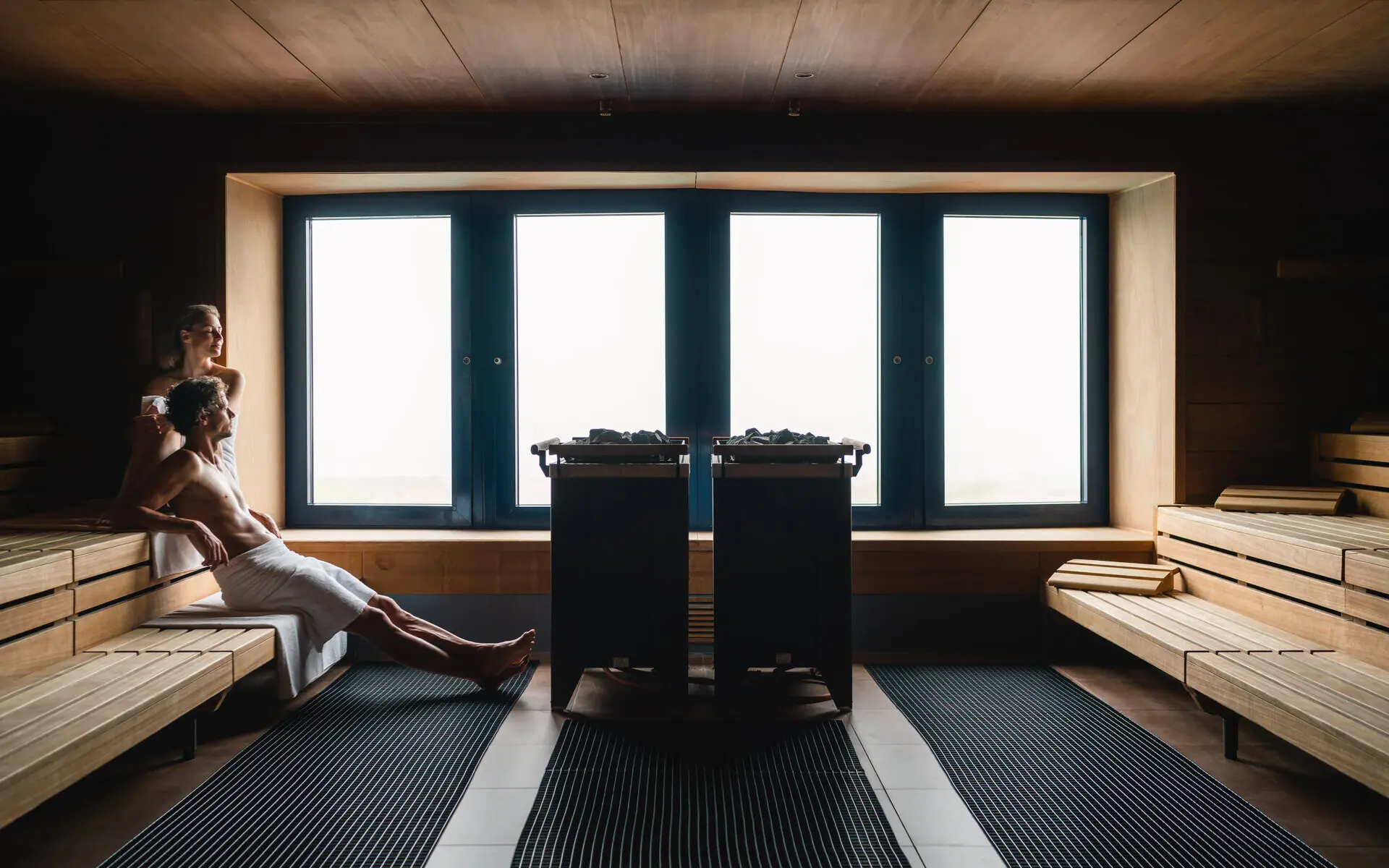 Person sitting on a bench in a sauna.