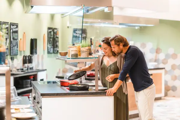 Ein Mann und eine Frau stehen neben einem Buffett.