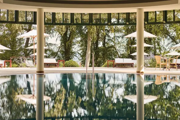 Indoor pool A pool with parasols and chairs in the background.