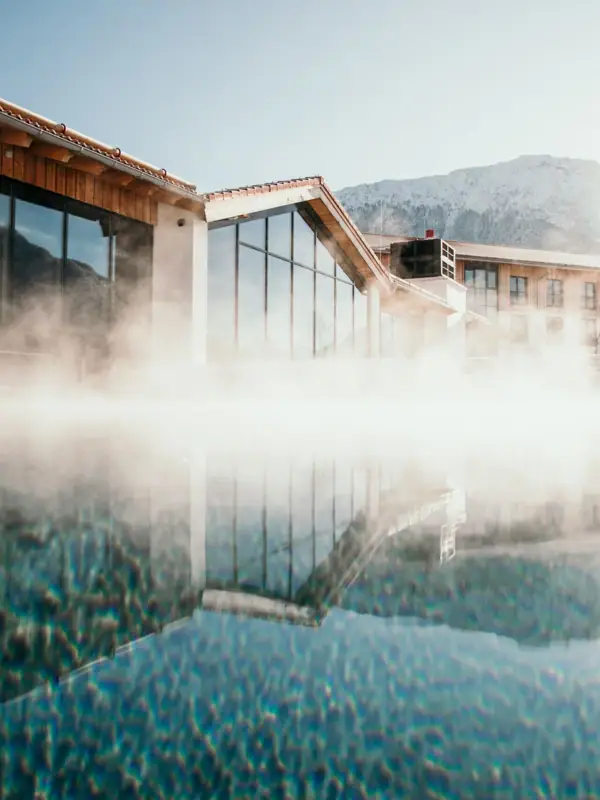 A building with a body of water and a mountain in the background.