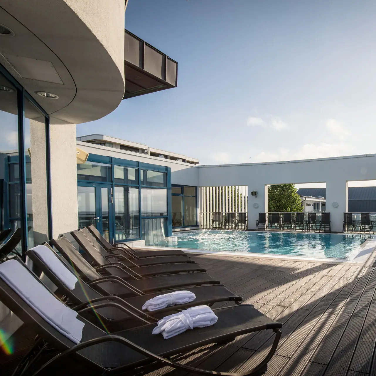 Outdoor pool Grömitzer Welle A pool with sun loungers and an outdoor deck.