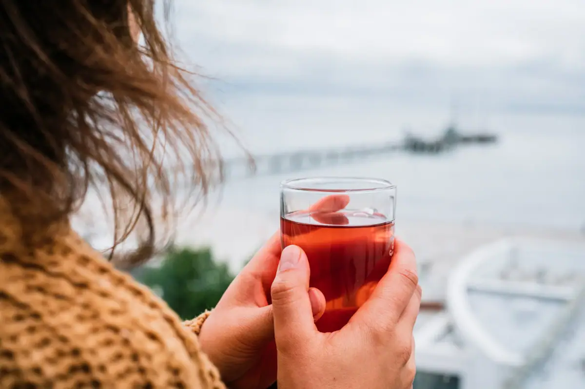 A person is holding a glass of tea.
