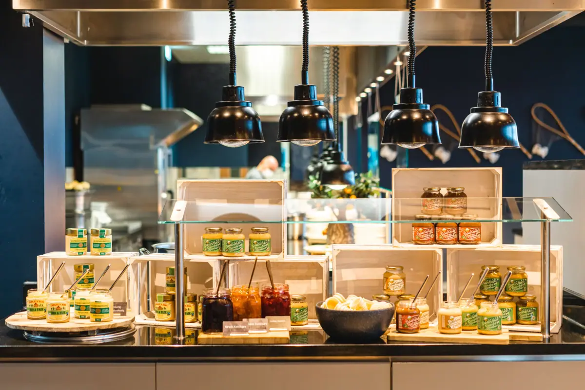 A counter with glasses and a bowl of jam.
