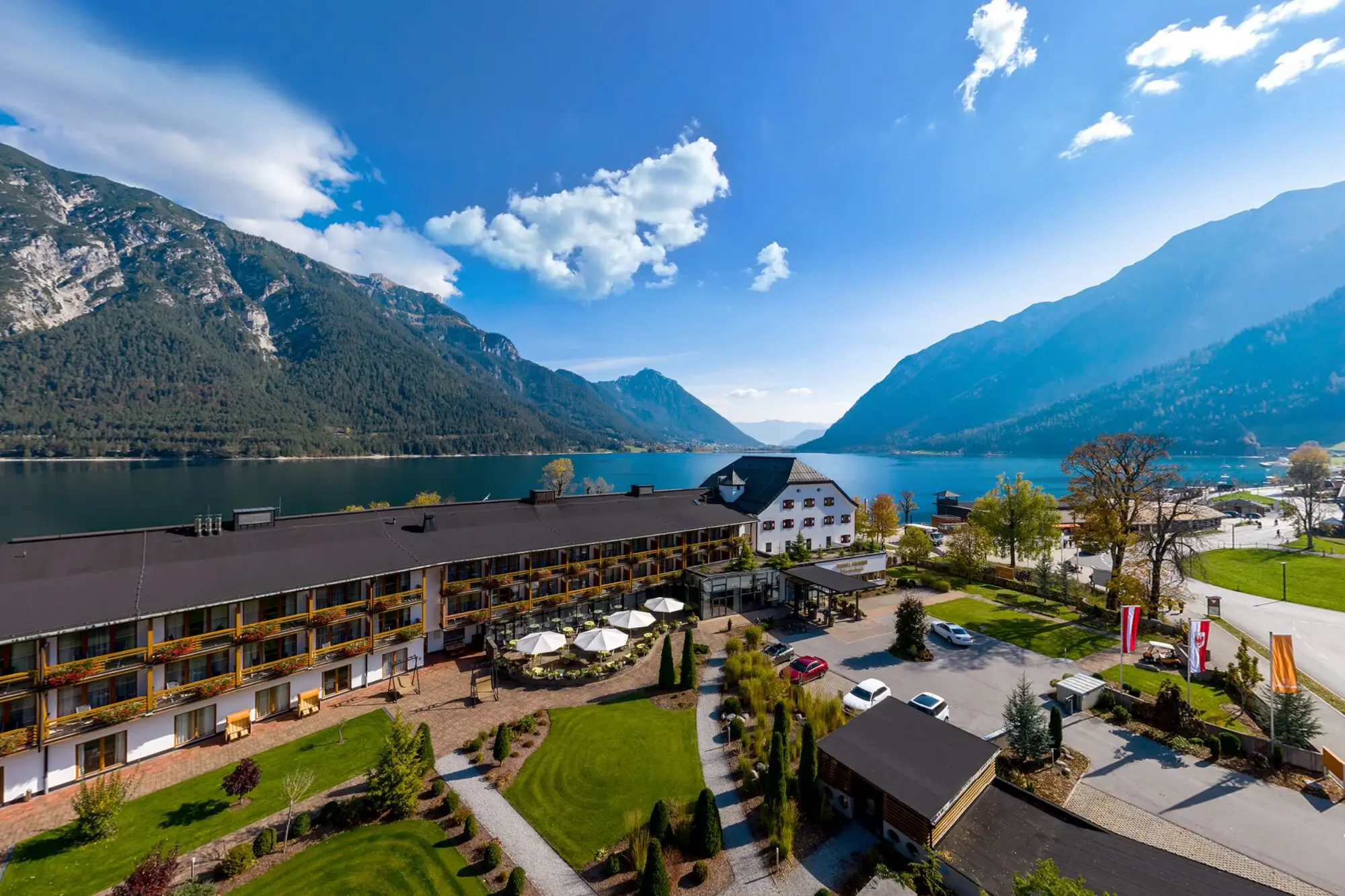 The aja Fürstenhaus am Achensee is located directly on Lake Achensee, surrounded by trees and mountains.