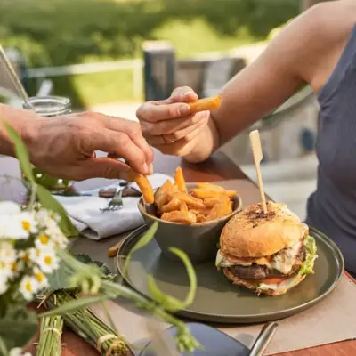 A woman eats a burger and fries.