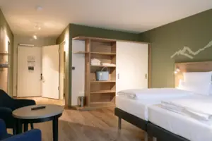 A room with a bed and some chairs.