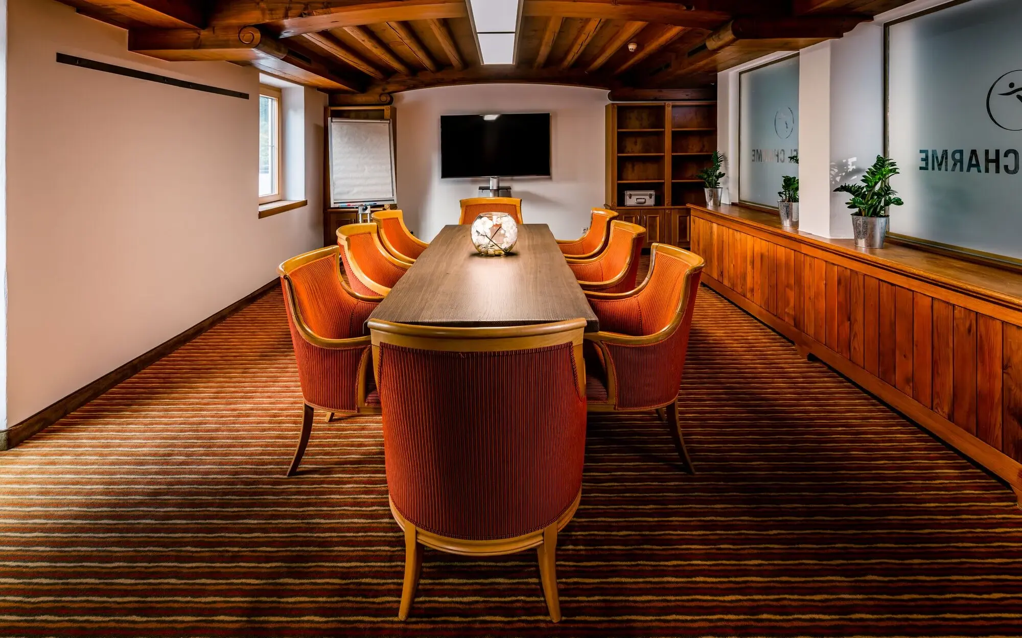 Meeting room with a table and chairs, with a vase on the table.