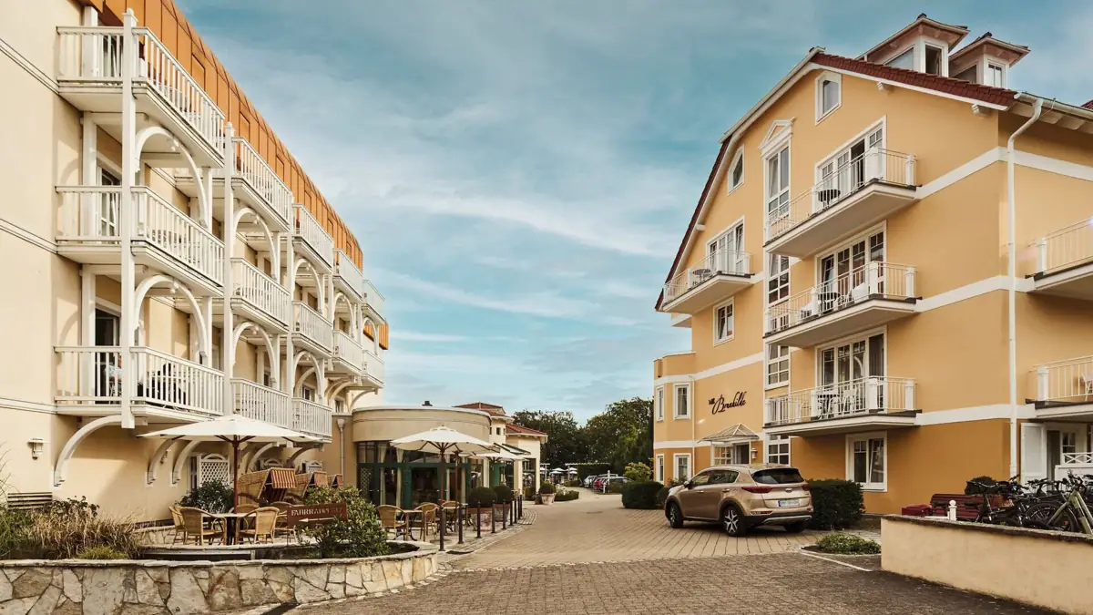 Hotel driveway Street with buildings and parked cars.