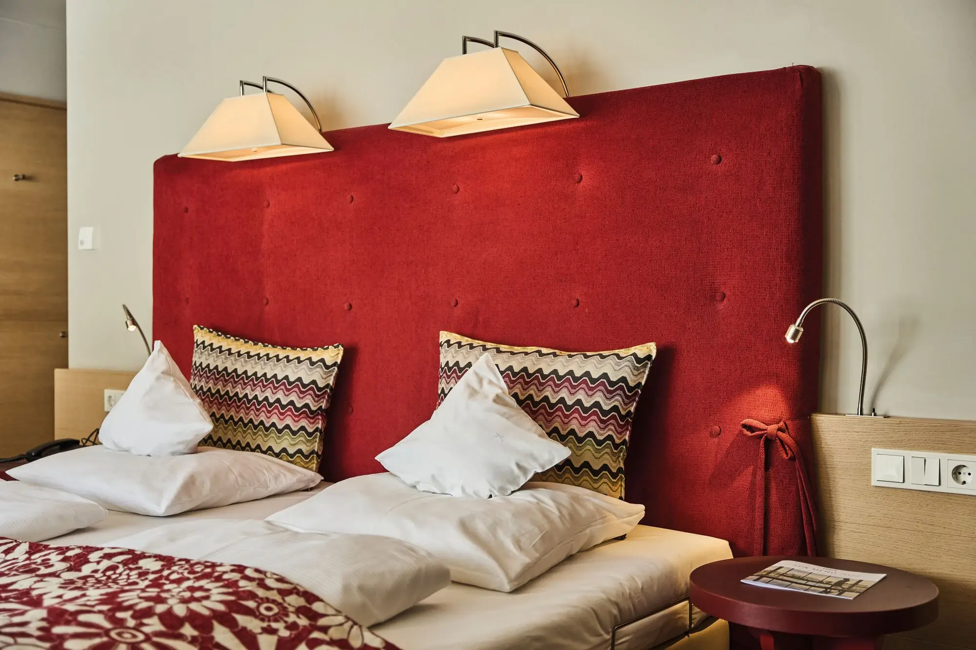 A bed with pillows and a lamp in an interior room.