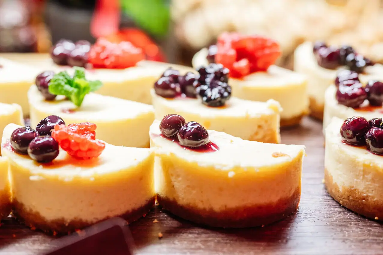 A group of small cheesecakes with berries on top.