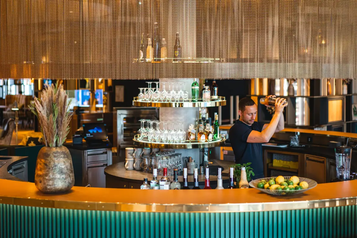 A man pours a drink in a bar.