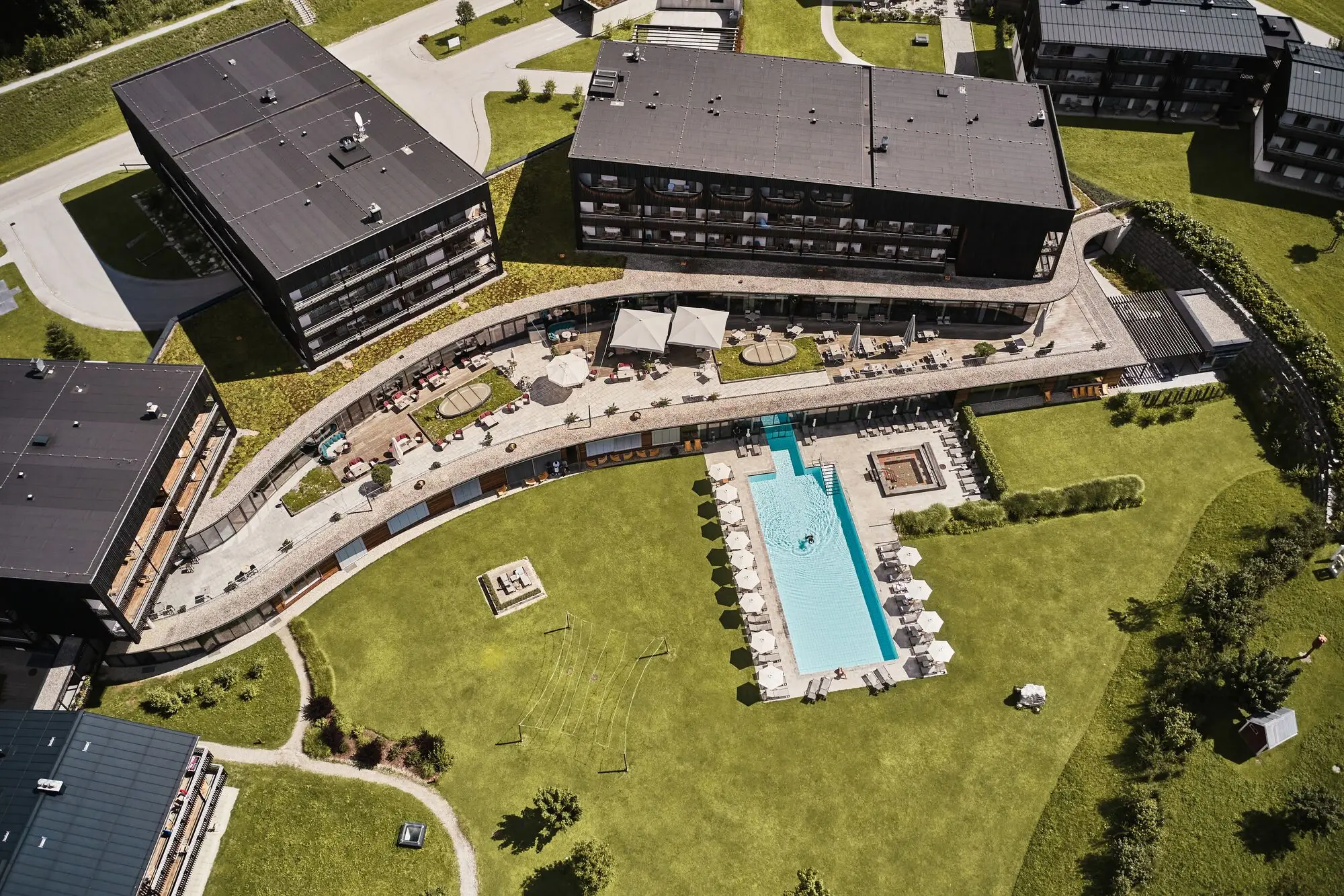 Hotel pool with surrounding urban design viewed from above.