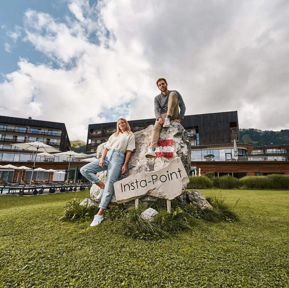 Insta-Point A man and a woman are sitting on a rock with a sign.