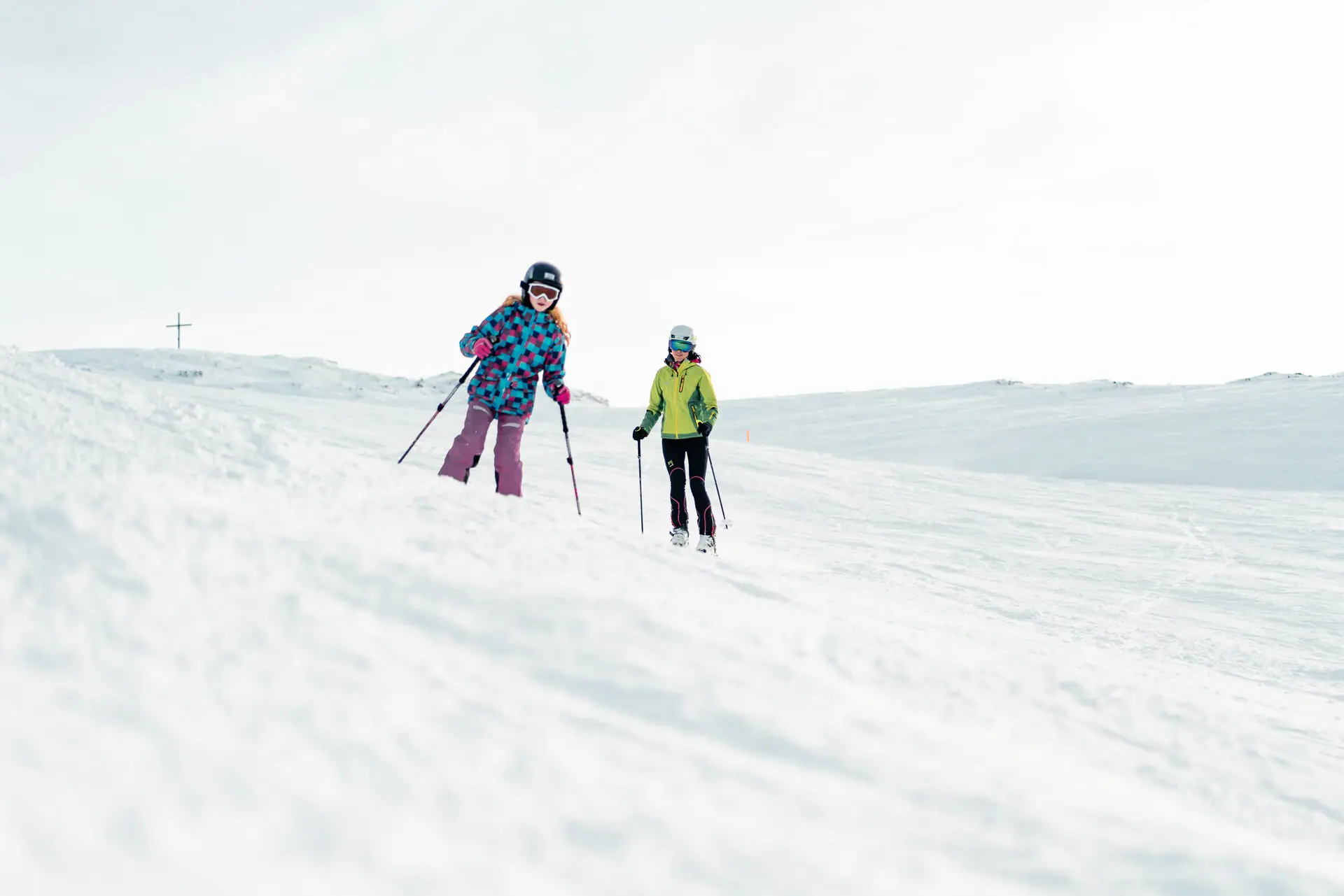 Ski piste Two people skiing on a snowy hill.
