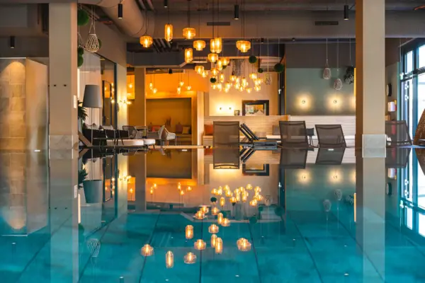 Innenpool Ein moderner Innenpool Bereich mit Liegen und Lampen im Hintergrund.