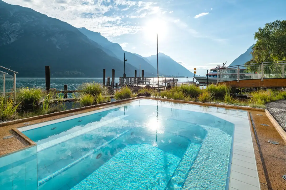 A pool with a jetty and mountains in the background.