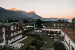 Eine Gruppe von Gebäuden mit Bäumen und Bergen im Hintergrund.