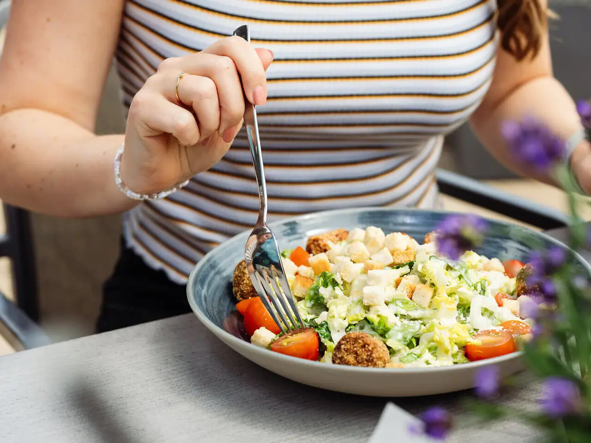 A woman eats a salad.