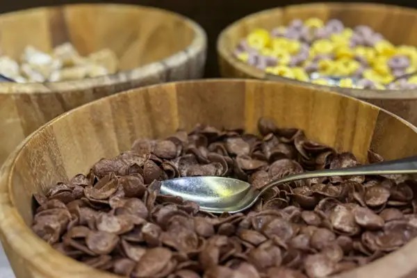 A bowl of cornflakes with a spoon in the background Other types of cornflakes