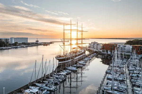 Travemünde Ein großes Schiff im Hafen bei Sonnenaufgang.