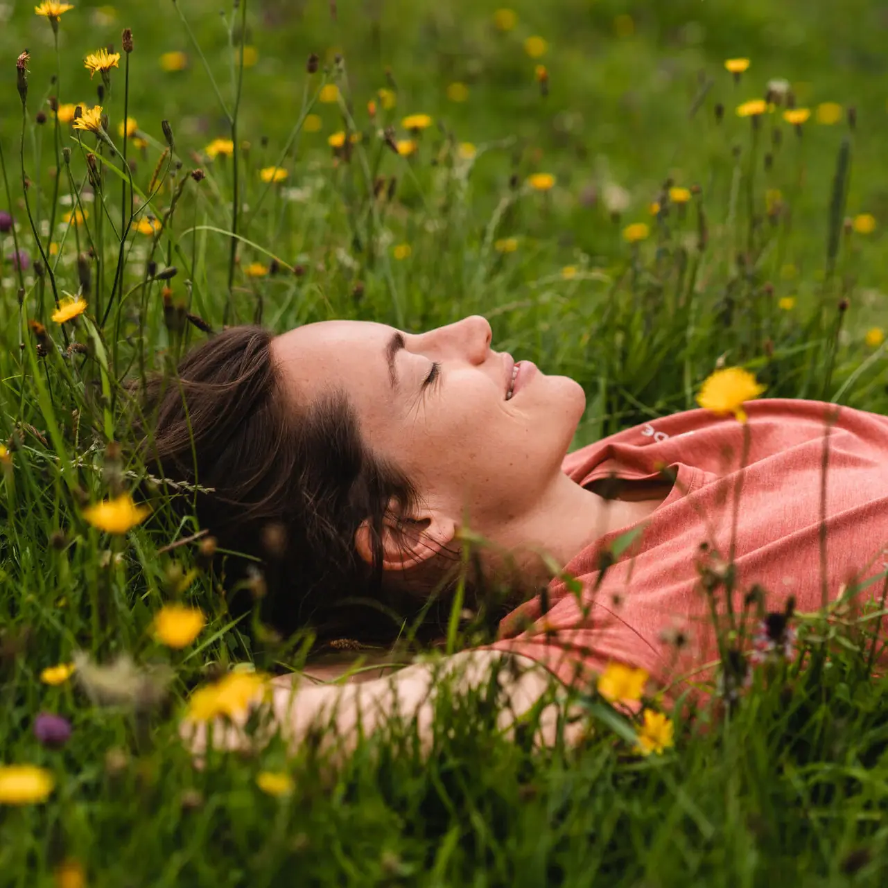 A woman lies on the grass with her eyes closed while on holiday in Garmisch-Partenkirchen.