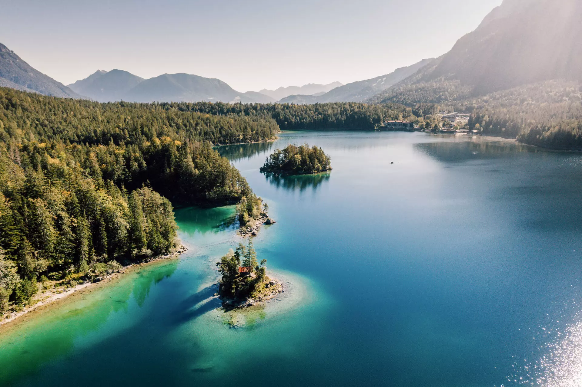 Eibsee A lake surrounded by trees and mountains.