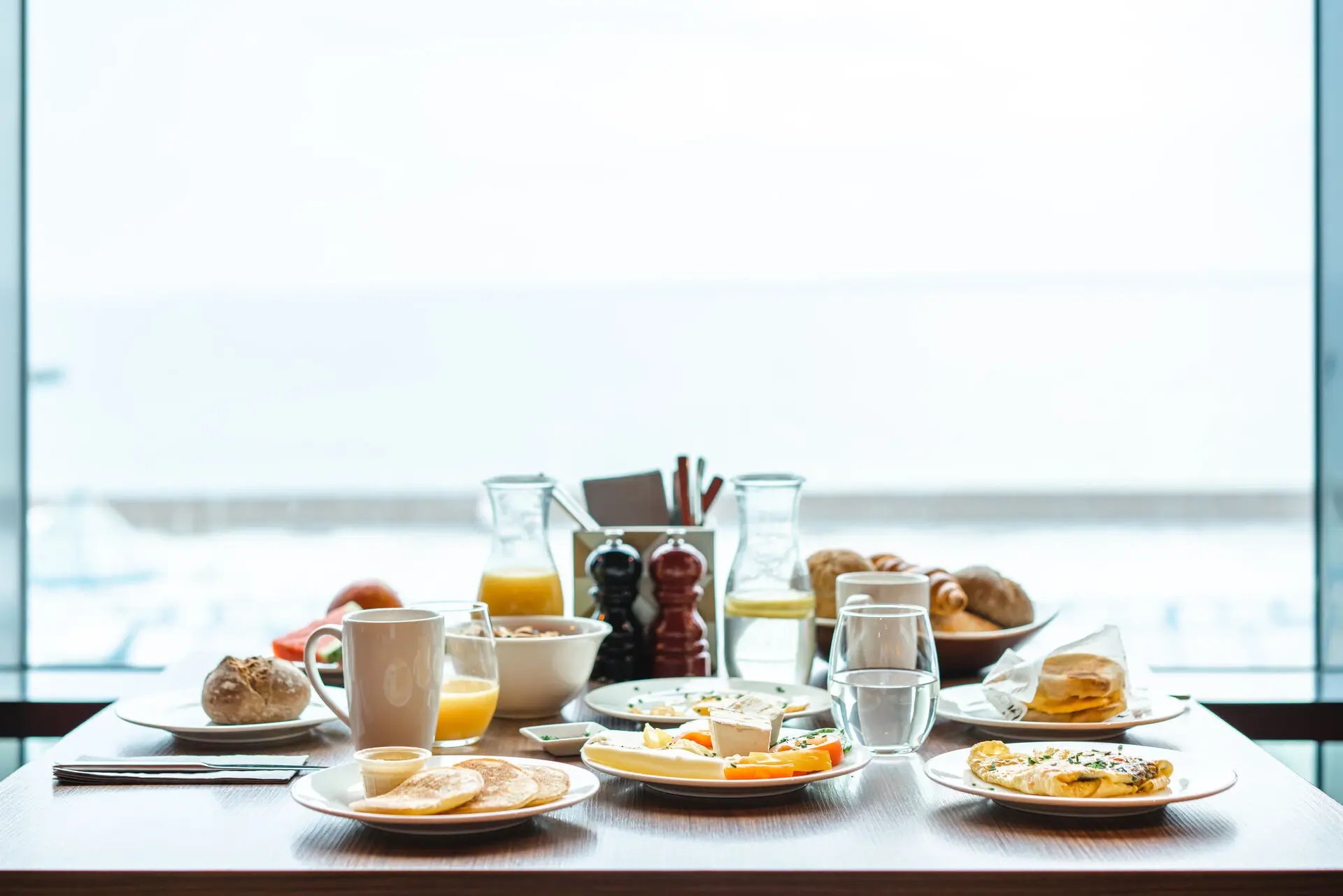 A table with plates full of food and drinks